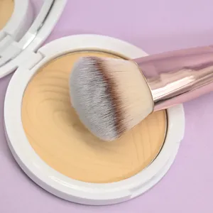 Detailed shot of a makeup brush resting on a pressed powder compact against a purple backdrop.