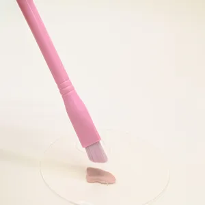 Ροζ λοξό τριγωνικό πινέλο concealer με απαλές τρίχες και διαφανή παλέτα μακιγιάζ.