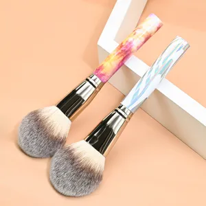 Closeup of two large fluffy makeup brushes featuring colorful marble and holographic handles.