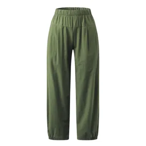 Gros plan sur le pantalon sarouel vert à taille élastique et texture de tissu douce.