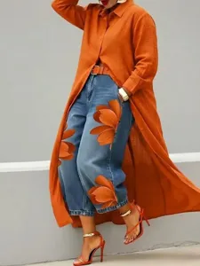 Gedetailleerd overzicht van het lange oranje vest gecombineerd met hippe bloemenjeans.