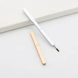 Detailed close-up view of portable retractable lip brushes in silver and gold metal cases.
