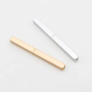 Portable retractable lip brush detail shot, elegant metal case in gold and silver colors.