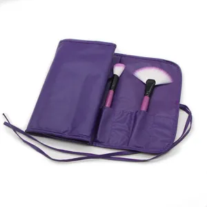 Dettaglio della custodia a rotolo per pennelli da trucco viola con due pennelli cosmetici.