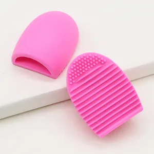 Silicone makeup brush cleaner detail, pink portable cosmetic tool with textured scrubbing surface.