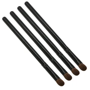 Vista detallada de cuatro brochas de maquillaje negras para sombra de ojos sobre blanco.