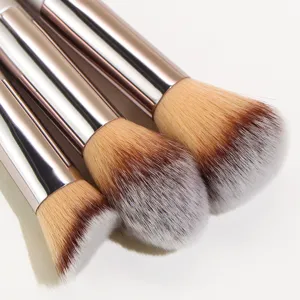 Professional makeup brush set with soft synthetic bristles and elegant champagne handles.