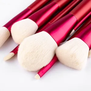 Red metal handle makeup brush detail, soft white synthetic bristles, professional tool.