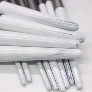 White marble makeup brush handle detail, tapered design for professional cosmetic application.