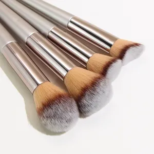 Champagne makeup brush detail view showing soft synthetic bristles and metallic handles.