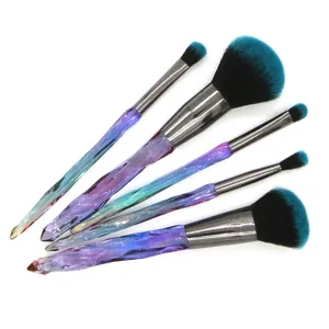 Close up detail view of five multi-functional makeup brushes with crystal diamond handles.
