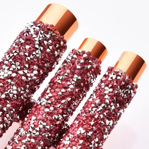 Close-up detail of luxury rhinestone makeup brush handle with shimmering crystals and rose gold ferrule.