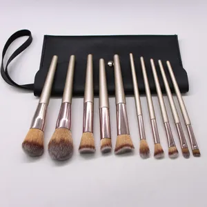 Detail view of 10-piece champagne makeup brushes with soft bristles and black leather pouch.