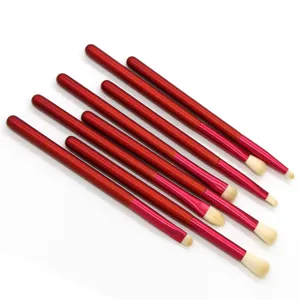 Red handle makeup brush detail view, soft bristles for precise eye shadow application.