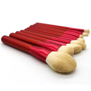 Detailed shot of red handle makeup brushes set with soft beige bristles for professional beauty.