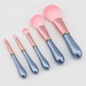 5-piece pink rhinestone makeup brush set with elegant blue handle for flawless cosmetic application.