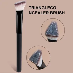 Primer plano del pincel corrector triangular con cerdas suaves y mango ergonómico.