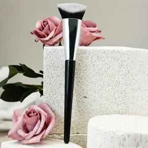 Détail de pinceau de maquillage professionnel, manche noir, poils doux pour fond de teint.