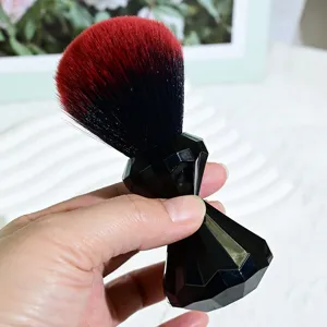 Close-up detail of soft gradient red and black bristles with elegant black diamond handle.