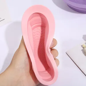 Silicone makeup brush cleaning bowl detail, soft foldable washing tool in pink color.