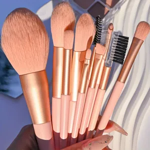 Zehn rosafarbene Make-up-Pinsel mit Roségold-Metallzwingen zeigen weiche Borsten in Detailansicht.
