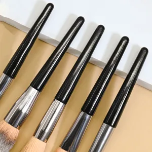 Close-up detail of black handle makeup brush with soft bristles, perfect for powder and contour.