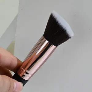 Vista detallada de brocha de maquillaje angulada con férula oro rosa para contorno.