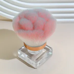 Detailed view of the fluffy gradient makeup and nail dust brush with a clear square base.