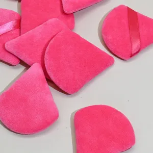 Close up detail of hot pink velour powder puff, soft sponge surface with ribbon for makeup.
