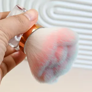 Close-up detail of soft fluffy bristles and clear handle on the portable makeup brush.