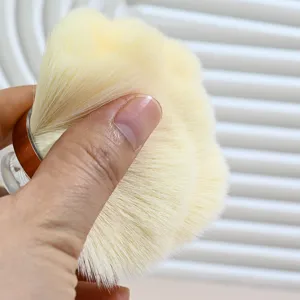 Close-up detail of soft makeup brush bristles with dense yellow fibers, perfect texture view.
