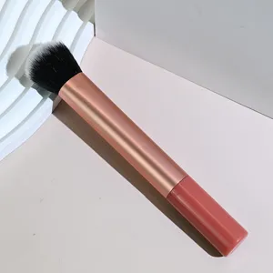 Primer plano de una brocha de maquillaje profesional de mango largo con cerdas suaves bicolor.