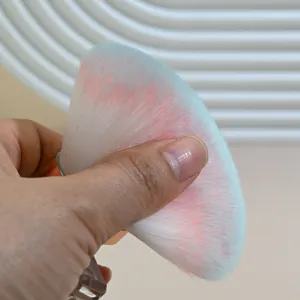 Soft gradient makeup brush detail shot showing fluffy bristles and ergonomic transparent handle.
