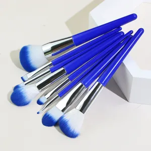 Detail view of professional makeup brush set with dark blue handles and soft gradient bristles.