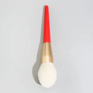 Make-up-Pinsel Detailaufnahme mit rotem Stiel, goldener Zwinge und weissen Borsten.