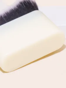 Detailed view of flat foundation makeup brush with dense bristles and white handle base.