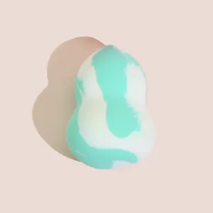 Gedetailleerd overzicht van de pompoenvormige make-up spons, zachte textuur voor egale blending.
