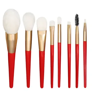 8-teiliges Make-up-Pinsel-Set mit weißen Borsten, goldenen Zwingen und roten Holzteilen.