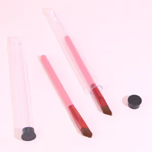 Pink angled eyebrow brush with clear storage tube and black cap for precise eye makeup.