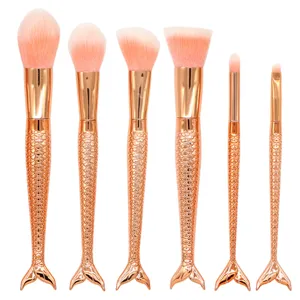 Set de 6 brochas de maquillaje de sirena con mangos oro rosa y cerdas rosas para cara y ojos.