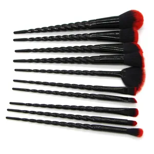 10-piece professional black unicorn makeup brush set with twisted handles and red bristles.