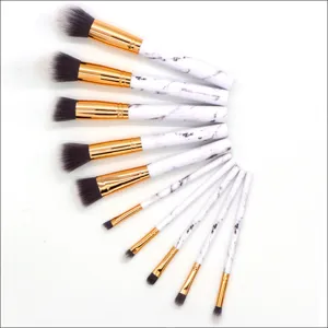 10-piece makeup brush set, white marble handles, gold ferrules, soft face and eye brushes.