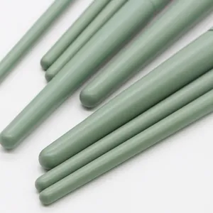 Detailed close-up of soft matcha green makeup brush handles, premium beauty tool design.