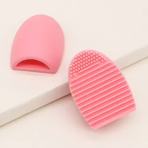 Silicone makeup brush cleaner pad in pink, detail view showing textured scrubbing surface.