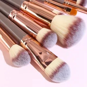Makeup brush set detail view featuring soft pink background and professional cosmetic tools.