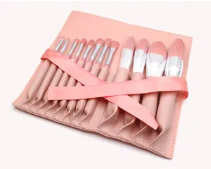 Close-up detail of the pink makeup brush roll bag with organized brushes and mesh.