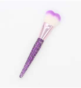 Heart shaped makeup brush detail showing purple glitter handle and soft gradient bristles.