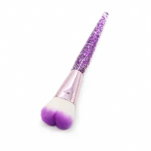 Heart-shaped makeup brush with purple glitter handle and soft gradient bristles for blush.