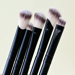 Nahaufnahme von fünf doppelendigen Augen-Make-up-Pinsel mit eleganten schwarzen Griffen.