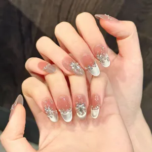 Faux ongles faits main avec dégradé cat-eye glacé et design scintillant de strass et flocons.